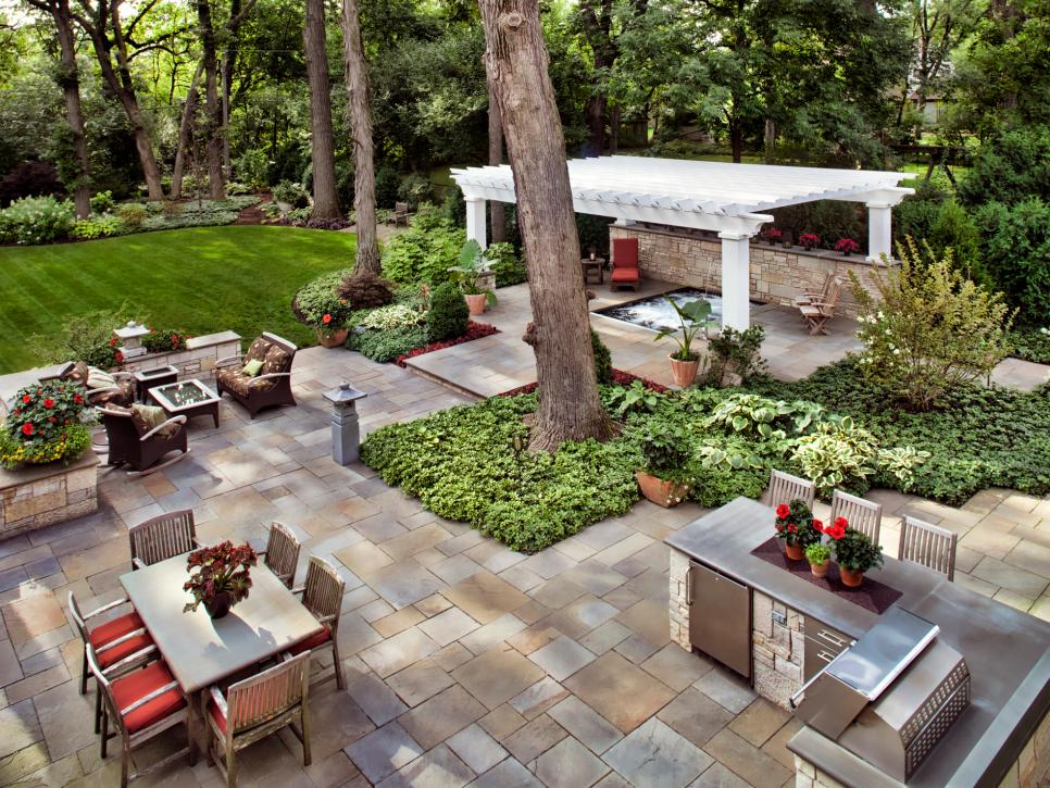The outdoor area of a welcoming home with plenty of seating and an outdoor kitchen. 